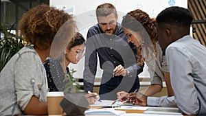 Focused multiethnic business people work together discuss paperwork at meeting photo