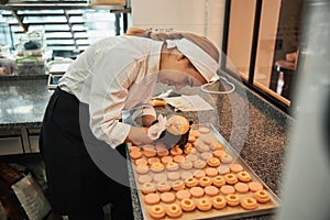 Focused pastry chef putting icing on custom-made macarons