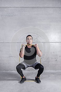Focused personal trainer doing exercise with elastic band