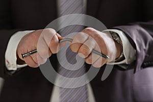 Focused photo on male hands that bending metal nail