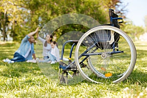 Focused photo on the wheelchair that standing empty on the foreground