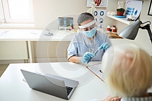 Focused physician getting out an autoinjector cap from a case