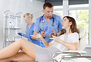 Focused physician talking to young female patient in clinic