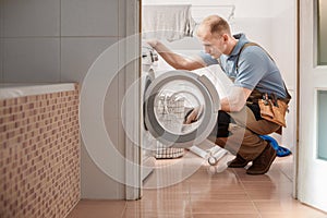 Focused plumber with toolbelt photo