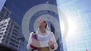 Focused and powerful business woman in front of a modern glass building