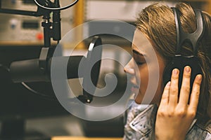 Focused pretty singer recording a song