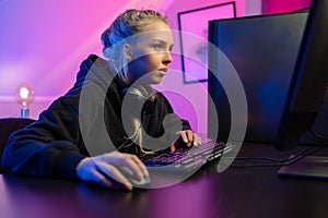 Focused Professional E-sport Gamer Girl Playing Online Video Game on PC