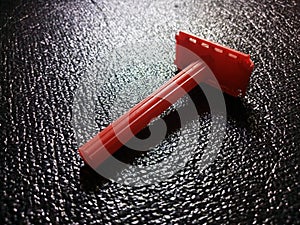 Focused Red Razor on Black Wrinkled Surface
