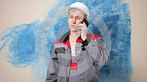 Focused repairman in casque talks to employer on phone