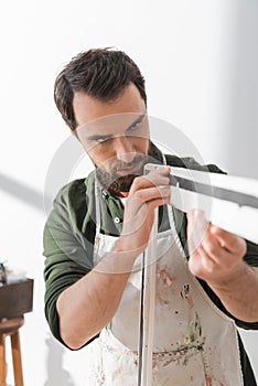 Focused restorer looking at wooden picture