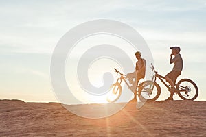 Focused on the road ahead. Full length shot of two young male athletes mountain biking in the wilderness.