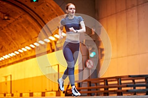 Focused runner running on road. redhead fit woman jog workout wellness concept.