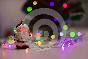 Delicated christmas scene with a santa claus ornament and bokeh colorful lights.