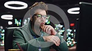 Focused scripter looking computer typing keyboard at night datacenter closeup
