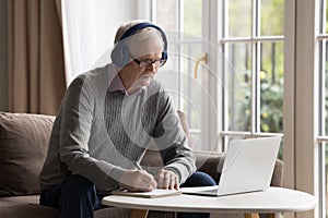 Focused senior man use notebook for online studying at home