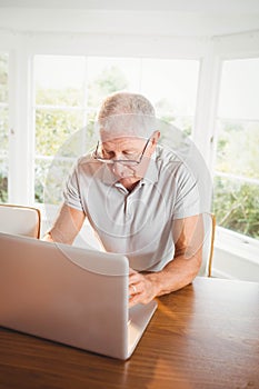 Focused senior man using laptop