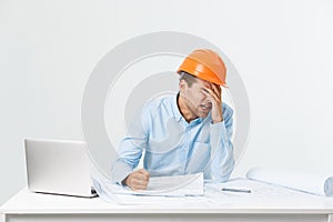 Focused serious hardworking engineer busy working on big architectural project late, sitting at his workspace using