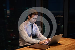 Focused serious young businessman working on computer.