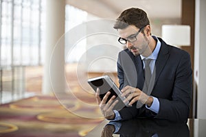 Focused Smart Young Businessman on Tablet photo