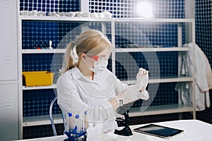 A focused student-science works in a lab with a petri dish. Chem