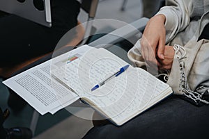 Focused student taking notes in notebook during lecture or seminar.