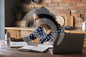 Focused student woman using headphones and laptop