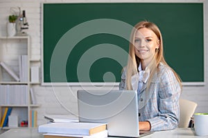 Focused student, young woman online watching webinar on laptop, listening learning education course, sit at work desk in