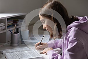 Focused teen girl study making assignment at home