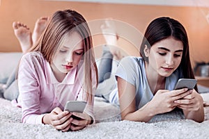 Focused two girls scrolling web pages down
