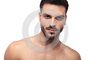 Focused undressed man with beard looking cool