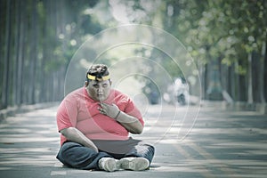 Focused view of fat Asian man patting his chest