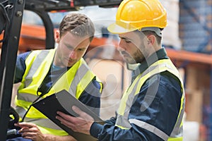 Focused warehouse workers talking together