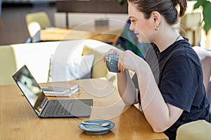 Focused Woman with Coffee Engrossed in Laptop Work