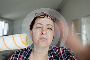 Focused woman examines defects on surface before painting