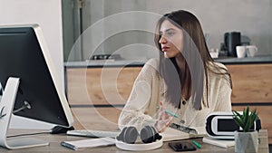 Focused woman making notes looking to computer screen. Working at home online concept