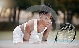 Focused woman waiting during a tennis match. Young african american woman holding her racket during a game of tennis