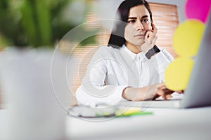 Focused woman working on laptop in office