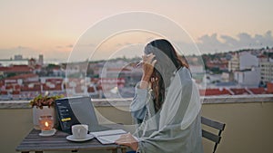 Focused woman working laptop on twilight balcony cityscape closeup. Girl writing