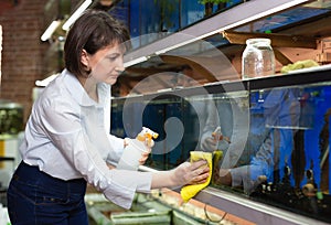 Woman washing glass of aquariums photo