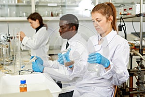 Focused woman lab technicians working with reagents and test tubes