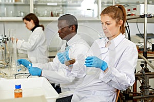Focused woman lab technicians working with reagents and test tubes