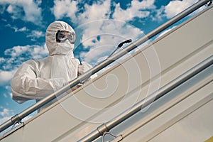 Focused worker disinfecting the handrail on the airstairs