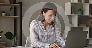 Focused young 25s caucasian woman working on computer.