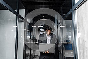 Focused young black businessman working online on laptop in office. Remote work.