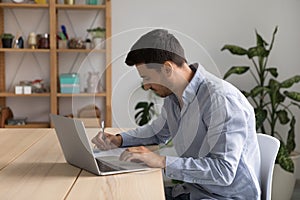 Focused young business professional man using laptop computer