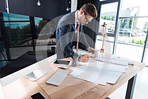 focused young businessman in eyeglasses working with papers