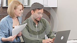 Focused young caucasian couple checking analyzing utilities bills at home