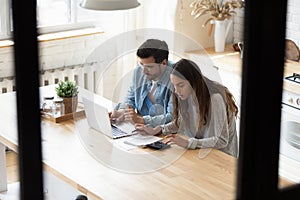 Focused young couple busy managing finances paying bills online