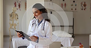 Focused young Hispanic doctor woman reviewing medical records