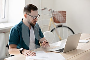 Focused male employee make notes watching webinar